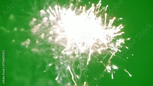 Bright white fireworks explode against a green background