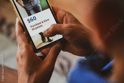 Customer loyalty program concept in e-commerce for customer engagement. Man holding phone displaying earning points after purchasing online.