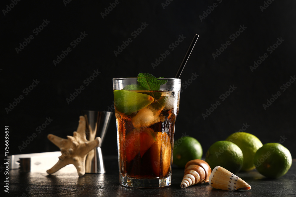 Φωτογραφία Glass of cold Cuba Libre cocktail with starfish, measure cup and seashells on bl