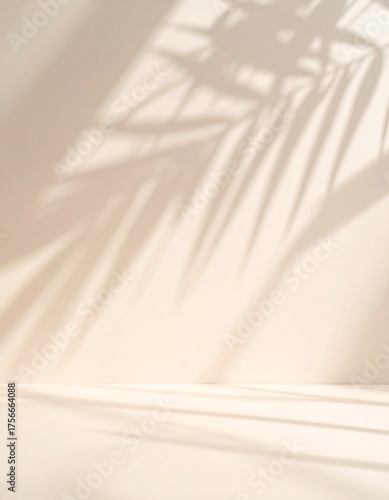Blurred shadow from palm leaves on light cream wall. Minimalistic beautiful summer spring background for product presentation.