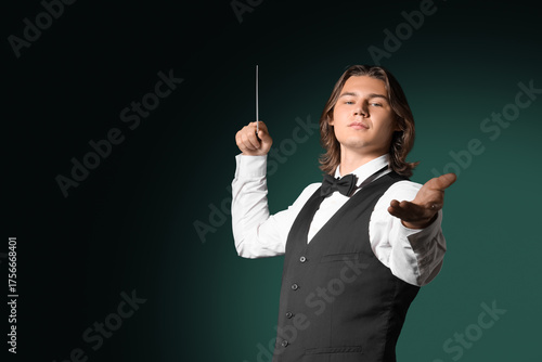 Male conductor on dark gree...