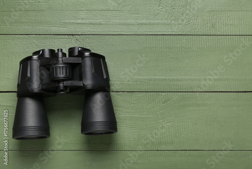 Modern binoculars on green ...