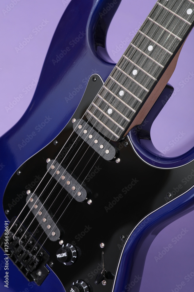 Fototapeta premium Modern electric guitar on lilac background, closeup