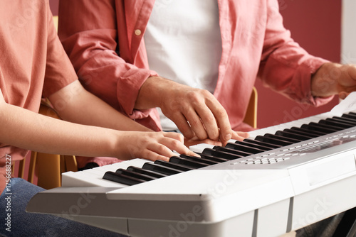 Adult and child hands playi...