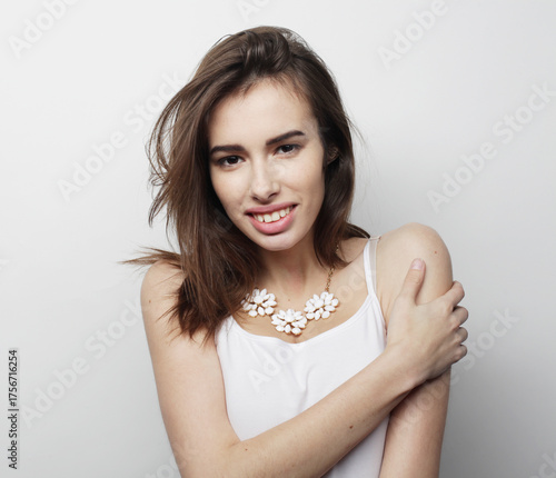 beautiful young woman wearing casual clothes, posing on light grey background.