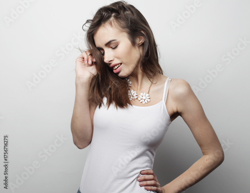 beautiful young woman wearing casual clothes, posing on light grey background.