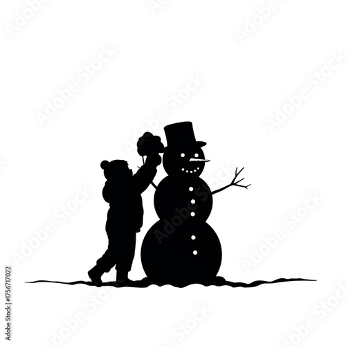 Child building snowman in winter.