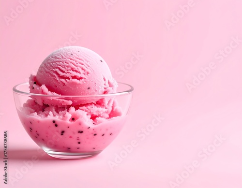 A Delicious Scoop of Pink Ice Cream with Dark Specks in a Glass Bowl on a Light Pink Background