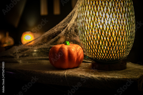 Spiderwebs across pumpkin and lanterns in a halloween festive party decor