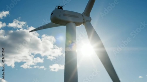 Modern Wind Turbine Generating Clean Renewable Energy Under Bright Blue Sky With Sunlight And White Clouds