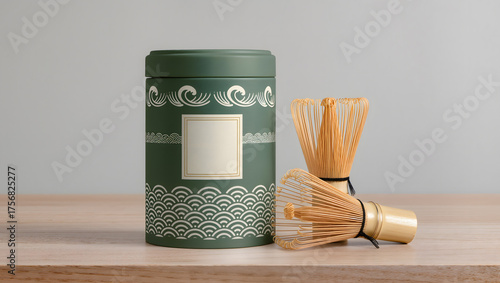 Premium tea tin packaging with minimalist Japanese pattern and matcha whisk beside it.