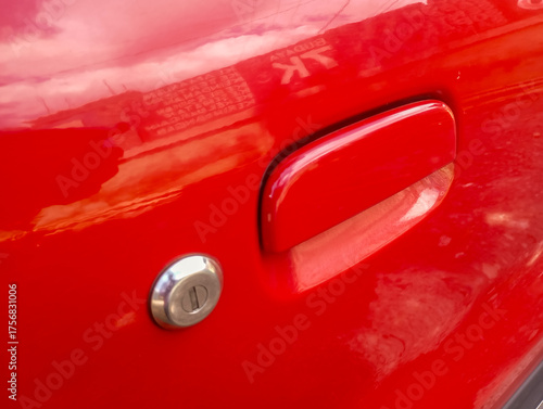 The bright red car door handle sparkles