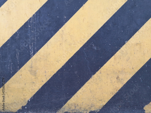 Textured Concrete Surface with Diagonal Yellow and Dark Gray Stripes