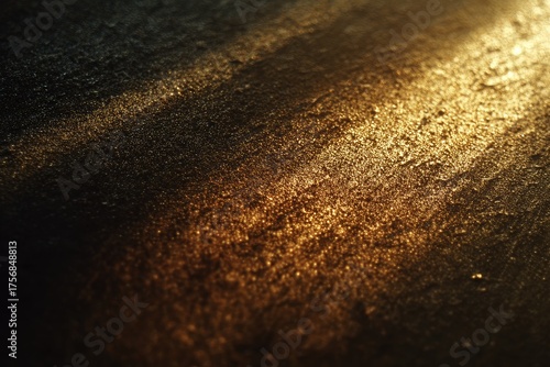 Close-up of textured surface with golden highlights and dark shadows. Abstract, grainy, and atmospheric