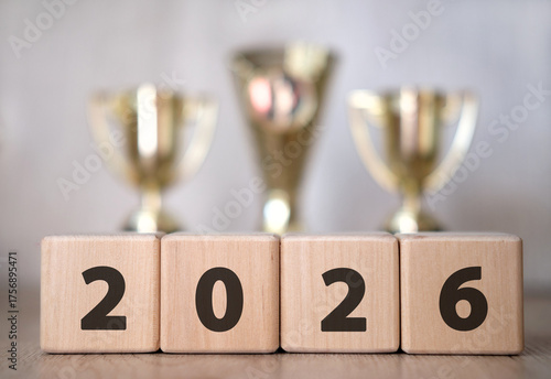 New year 2026 concept. Plain background text. Winners' Cups in the background