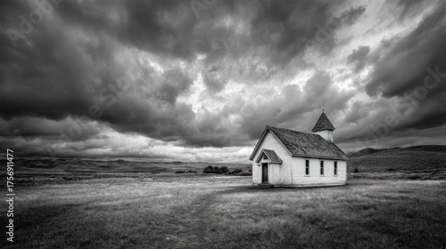 Solitary, small, white church stands isolated beneath a dramatic, cloudy sky