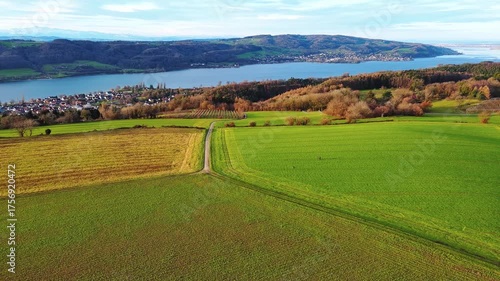 Agricultural meadows, spring forests and a small village on the banks of the river Rhine with hills in the background