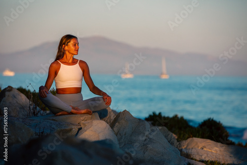 Woman enjoys yoga at sunset on the beach in Santa Barbara, California.