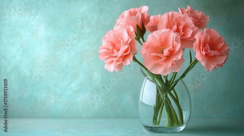 Wallpaper Mural Delicate pink carnations arranged in a clear glass vase against a soft turquoise textured background conveying freshness and elegance Torontodigital.ca