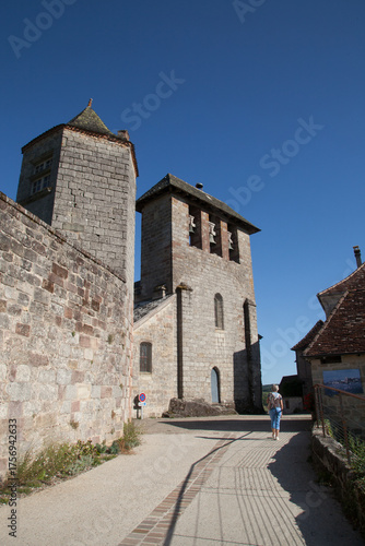Touriste marchant vers l'église de Curemonte plus veau village de France (Corrèze)