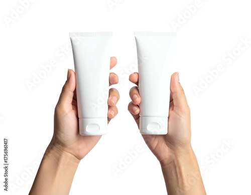 Two white cosmetic tubes held upright by two hands against a stark black background