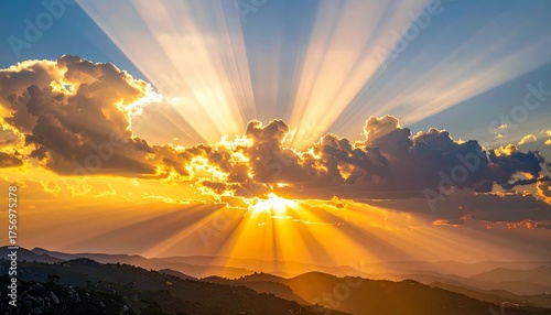 Golden sunbeams pierce dramatic clouds over layered mountain ranges at dawn, creating a breathtaking, hopeful natural spectacle for serene backdrops and inspirational use