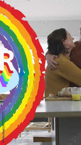 Animation of rainbow and queer over lesbian couple in kitchen