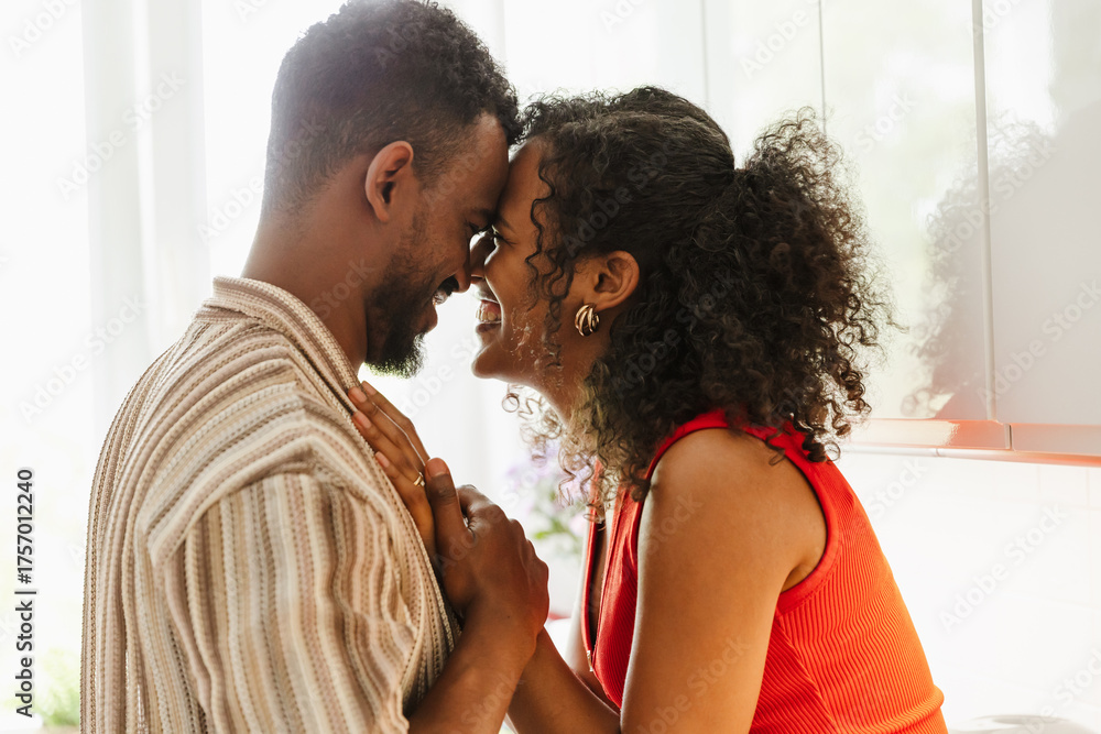 Obraz premium A man and a woman touch their foreheads and smile while she puts her hand on his chest