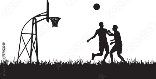 Two men playing basketball on a grassy field silhouette