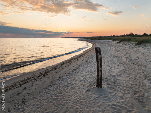 Fototapeta Naklejka Na Ścianę i Meble -  Aerial drone view of the scenic sandy beach coast of the Baltic Sea in Perakula, Estonia during a tranquil sunset.