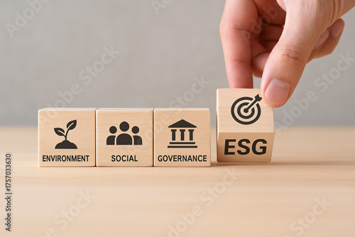 Hand placing ESG block in a set of wooden cubes representing Environment Social Governance