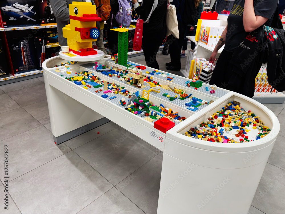 Naklejka premium Lego brick display table in store filled with colorful bricks and playful figures