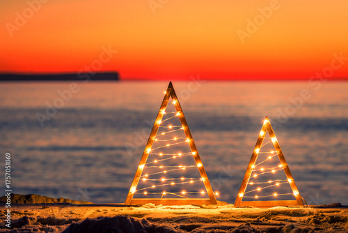 Simple Christmas Tree and Fairy Lights on beach at sunrise
