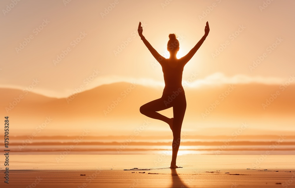 Fototapeta premium A serene scene unfolds as a woman gracefully performs yoga on a beach at sunrise, capturing the essence of peace and connection with nature