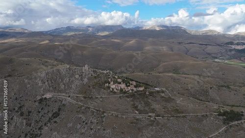 Drone aerial view of Monte Calascio, Abruzzo, featuring the medieval Rocca fortress and spectacular surrounding mountain landscapes