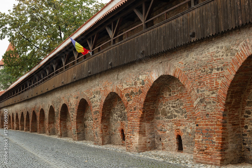 A fragment of the old defensive walls in the Romanian city of Sibiu. The Romanian flag.