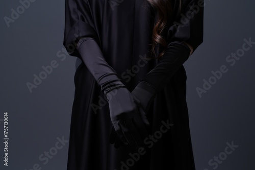Elegant Black Attire: A Mysterious Fashion Statement with Long Gloves and a Dark Background