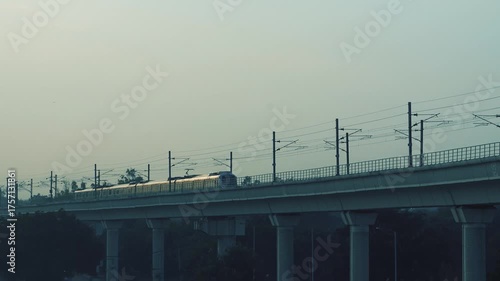 Delhi metro train moving on track during evening golden light