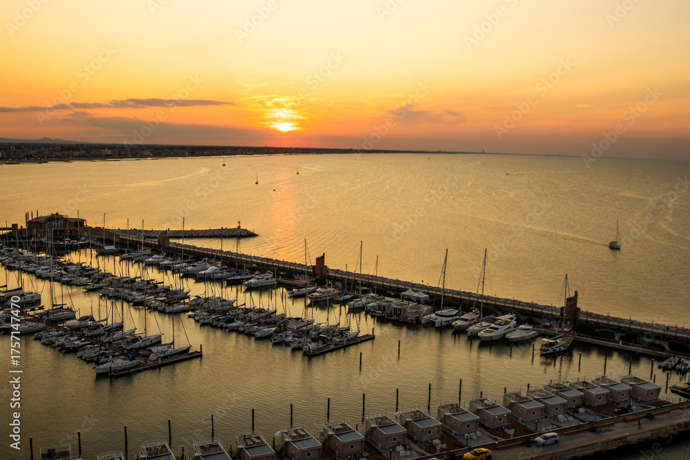 Obraz premium Italy yacht club top view. The sky in the evening. Water sea parking ships. Sunset sky at seaport of Italian city of Rimini in Summer. Sun horizon