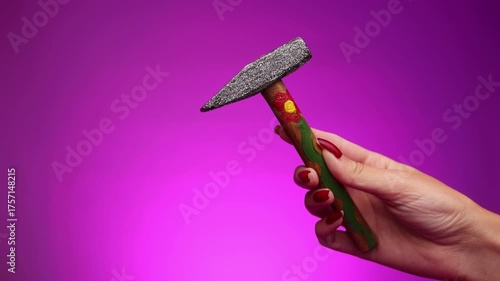A young woman holding a decorated hammer. Representing women's strength, women's rights, and women in the workforce. Feminism. Woman empowerment