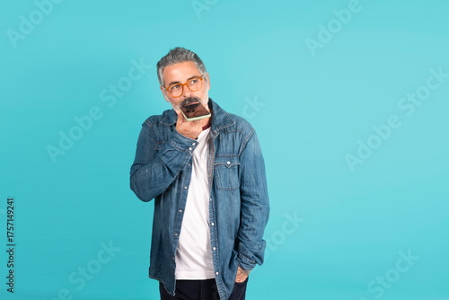 Photography Senior man dictating voice message on smartphone thinking