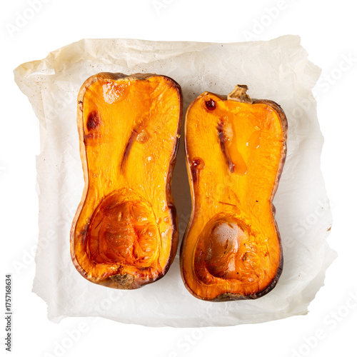 Roasted butternut squash halves on baking paper isolated on white background. Top view.