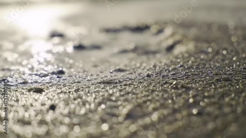 Macro shot of a single footprint on sunlit beach sand with soft focus background. Ideal for travel, solitude, mindfulness, and nature concepts.