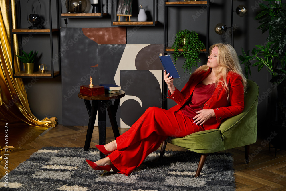 Obraz premium stylish lady enjoying tea and book, chic woman in red attire relaxing with reading material and tea