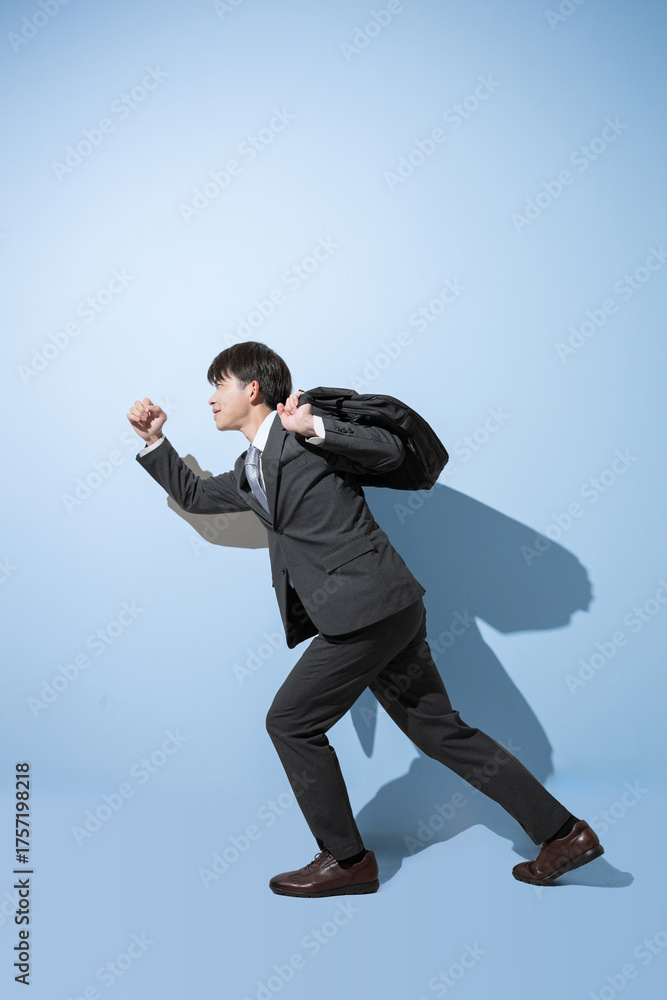 Obraz premium 通勤カバンを持つ走るポーズのスタートのような20代の新卒や就活、リクルートのイメージ全身横顔