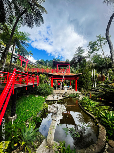 Bright red bridges and tranquil garden pavilion in Madeira Portugal with lush tropical scenery