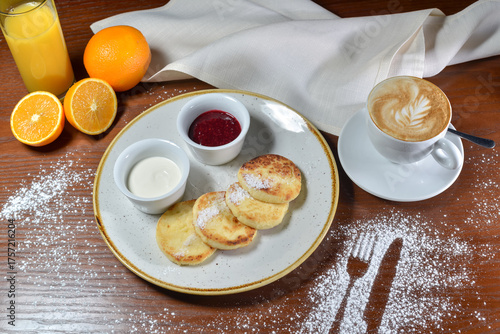 breakfast cheesecakes with sauces on a plate on the table with coffee