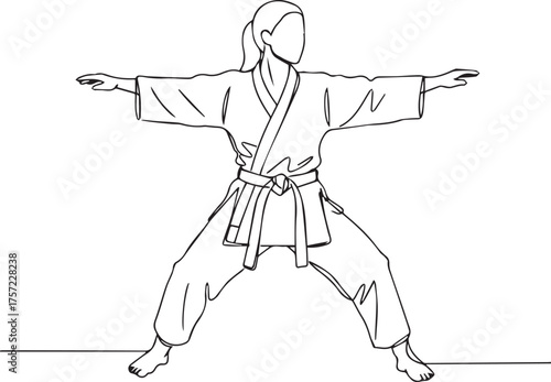 Woman in martial arts uniform performing a stance karate