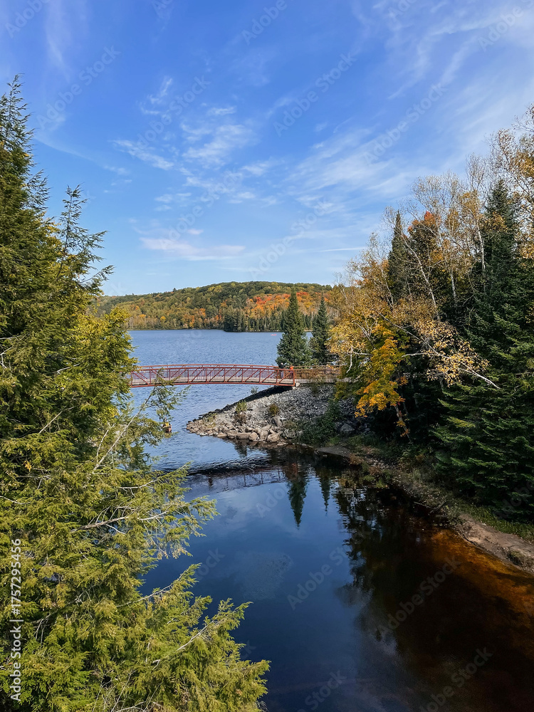 Fototapeta premium Autumn view of a bridge over a lake in the forest. Algonquin Park, Canada. 