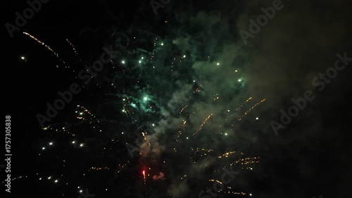 Bright colorful fireworks explode across dark night sky, creating festive and celebratory atmosphere, perfect for holiday videos, New Year events and festive background visuals